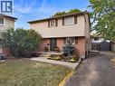 Two-story residence featuring brick and siding facade, concrete front walkway, established landscaping, and a paved driveway leading to a rear storage shed - 31 Berrisfield Crescent, Hamilton, ON 
