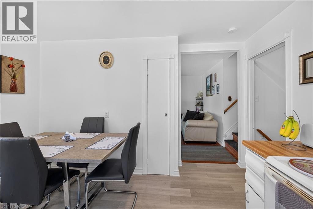 Neutral interior featuring wood-finish flooring, a tall built-in utility closet, and wood-surface kitchen cabinetry - 411 Queen Victoria Drive, Hamilton, ON