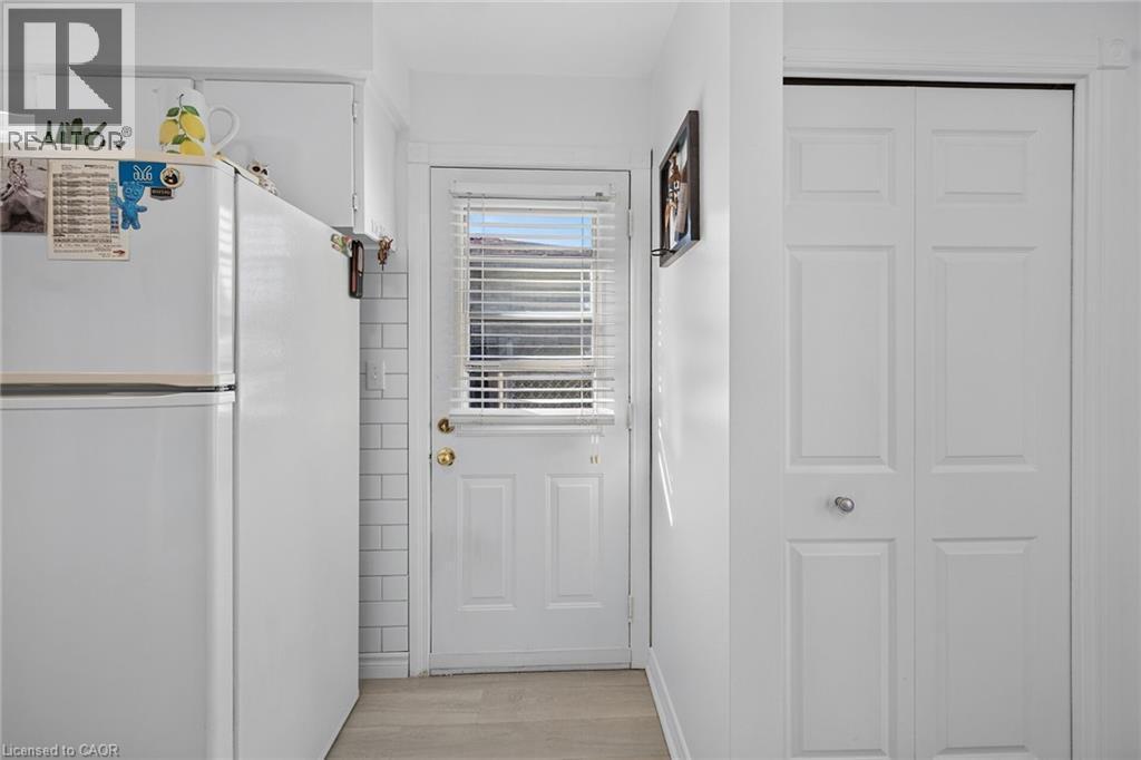 Exterior door with integrated window and horizontal blinds, white subway tile backsplash, and bifold closet doors - 411 Queen Victoria Drive, Hamilton, ON