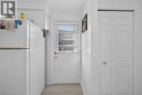 Exterior door with integrated window and horizontal blinds, white subway tile backsplash, and bifold closet doors - 411 Queen Victoria Drive, Hamilton, ON 