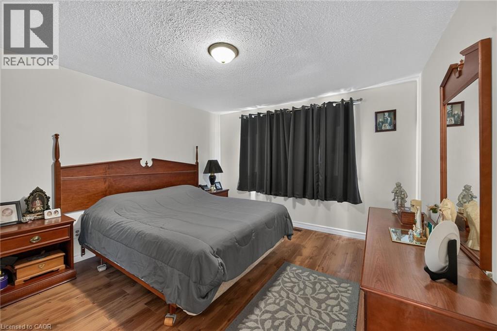 Room featuring wood-finish flooring and a central ceiling-mounted light fixture - 411 Queen Victoria Drive, Hamilton, ON