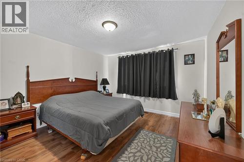 Room featuring wood-finish flooring and a central ceiling-mounted light fixture - 411 Queen Victoria Drive, Hamilton, ON 