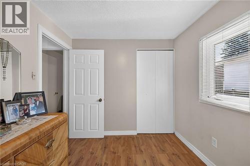 Wood-finish flooring, white six-panel interior door, and double-door closet with white finish - 411 Queen Victoria Drive, Hamilton, ON 
