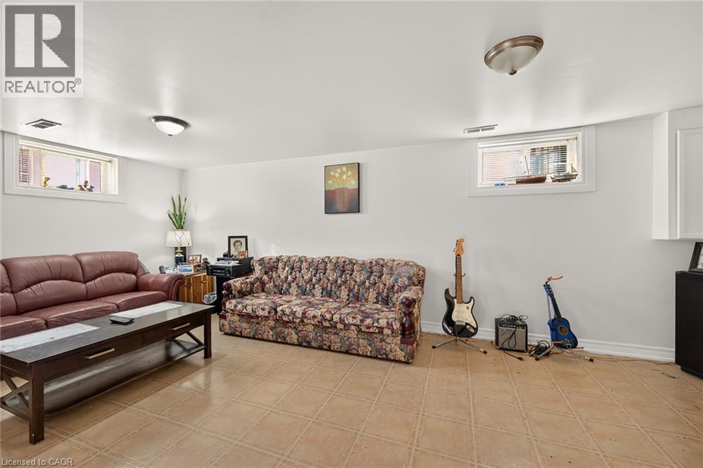 Neutral-toned ceramic tile flooring, dual recessed windows, and two flush-mount ceiling light fixtures - 411 Queen Victoria Drive, Hamilton, ON