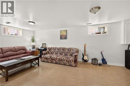 Neutral-toned ceramic tile flooring, dual recessed windows, and two flush-mount ceiling light fixtures - 411 Queen Victoria Drive, Hamilton, ON 