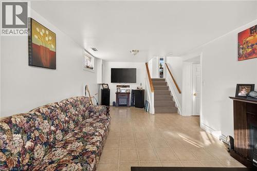 Neutral-toned tile flooring, staircase with wood-finish handrail, and recessed ceiling lighting - 411 Queen Victoria Drive, Hamilton, ON 