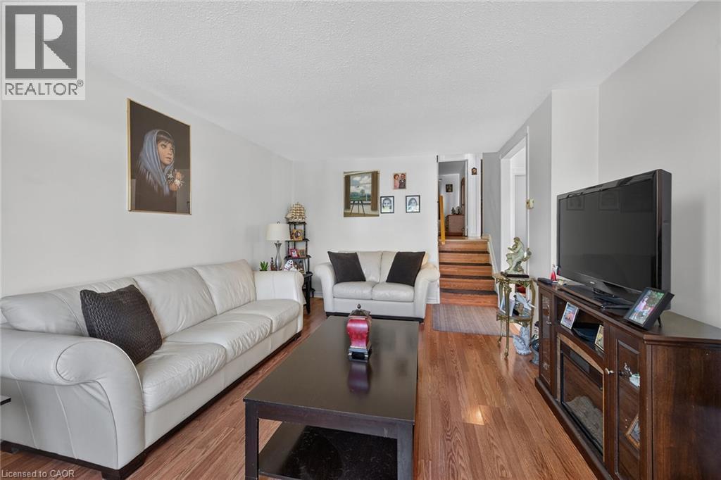 Living area featuring wood-finish flooring and a staircase with stained wood steps - 411 Queen Victoria Drive, Hamilton, ON
