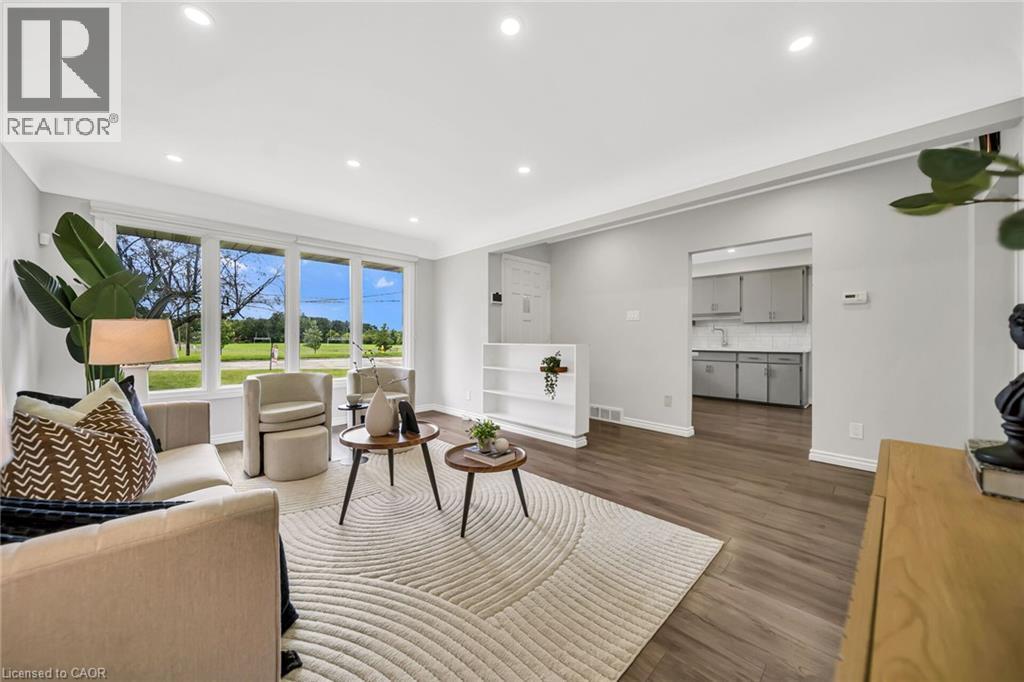 Expansive windows, recessed lighting, wood-finish flooring, built-in shelving, and a clean white color palette - 284 Cedar Crescent, Cambridge, ON - Indoor Photo Showing Living Room