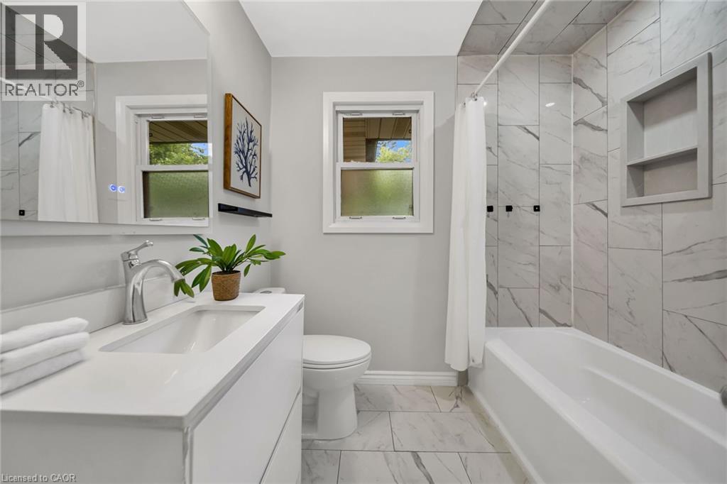 Contemporary vanity with an integrated rectangular sink, chrome faucet, and illuminated mirror - 284 Cedar Crescent, Cambridge, ON - Indoor Photo Showing Bathroom