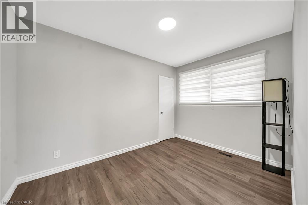 Recessed lighting, wood-finish flooring, white trim, and a window with blinds - 284 Cedar Crescent, Cambridge, ON - Indoor Photo Showing Other Room