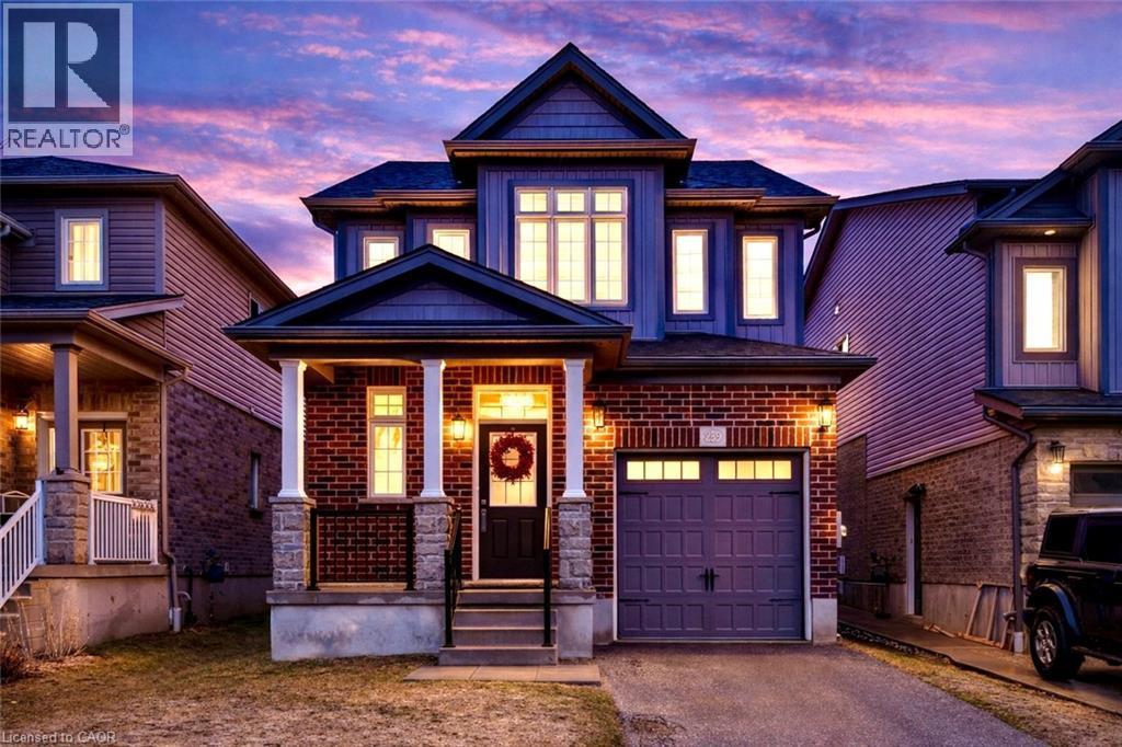 Craftsman-style house featuring asphalt driveway, a porch, a garage, and brick siding - 239 Cranbrook Street, Kitchener, ON - Outdoor