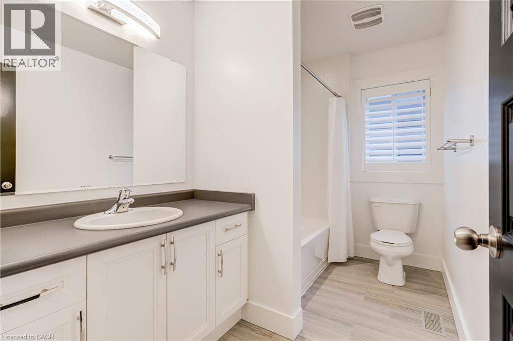 Bathroom with vanity, light wood finished floors, and shower / bath combo with shower curtain - 239 Cranbrook Street, Kitchener, ON - Indoor Photo Showing Bathroom