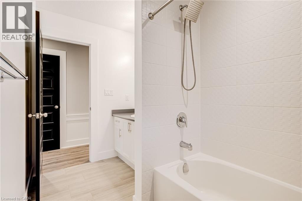 Bathroom featuring vanity, shower / washtub combination, and light wood-style floors - 239 Cranbrook Street, Kitchener, ON - Indoor Photo Showing Bathroom