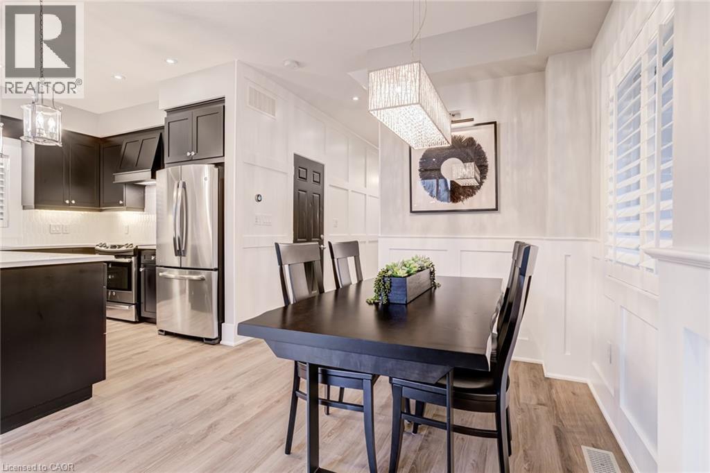 Dining area with suspended lighting, light wood-style flooring, a decorative wall, and wainscoting - 239 Cranbrook Street, Kitchener, ON - Indoor Photo Showing Dining Room