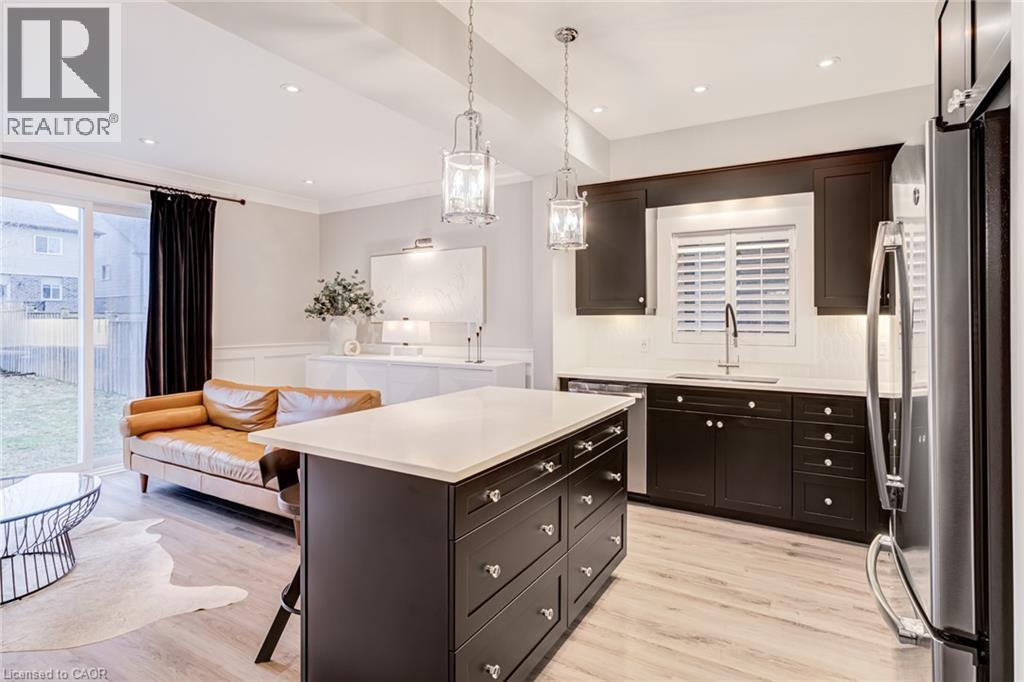 Kitchen featuring stainless steel appliances, a breakfast bar, open floor plan, a center island, and dark wood finish cabinets - 239 Cranbrook Street, Kitchener, ON - Indoor Photo Showing Kitchen With Upgraded Kitchen