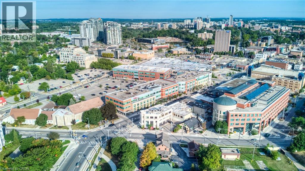 Urban landscape featuring diverse architectural styles, multi-story commercial buildings, and surface parking areas - 191 King Street S Unit# 607, Waterloo, ON - Outdoor With View