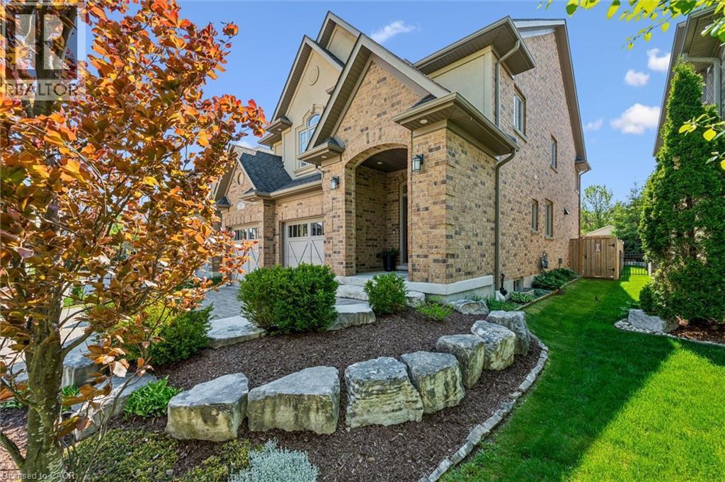 Brick facade residence featuring an arched entryway, gabled rooflines, and a two-car garage. - 828 Copper Ridge Drive, Waterloo, ON - Outdoor