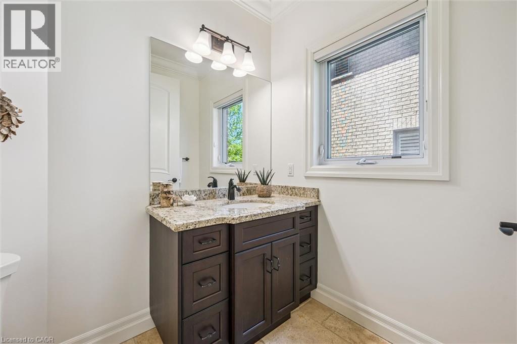 Powder Room vanity featuring a granite countertop, undermount sink, and matte black faucet - 828 Copper Ridge Drive, Waterloo, ON - Indoor Photo Showing Bathroom