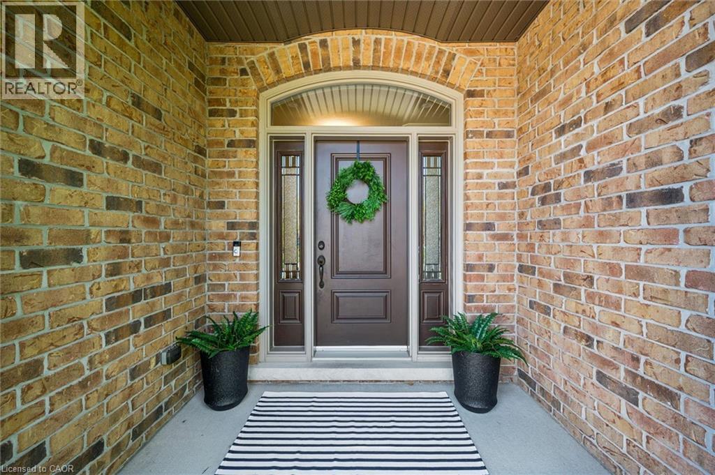 Arched entry featuring brick exterior, a dark wood-finish door, and sidelight windows with decorative glass. - 828 Copper Ridge Drive, Waterloo, ON - Outdoor