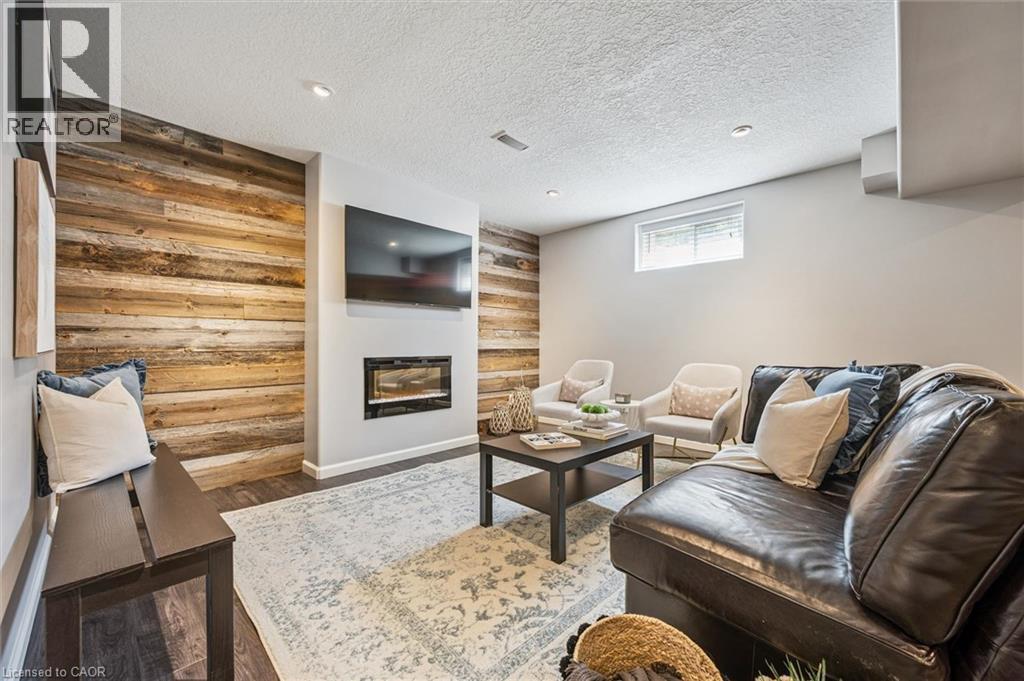 Accent wall featuring horizontal wood planks, recessed lighting, wood-finish flooring, and a modern built-in fireplace. - 828 Copper Ridge Drive, Waterloo, ON - Indoor With Fireplace