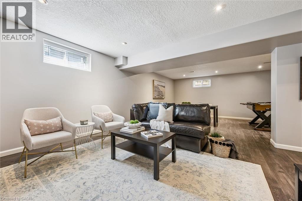 Spacious lower-level living area featuring recessed lighting, wood-finish flooring, and light-toned wall paint - 828 Copper Ridge Drive, Waterloo, ON - Indoor