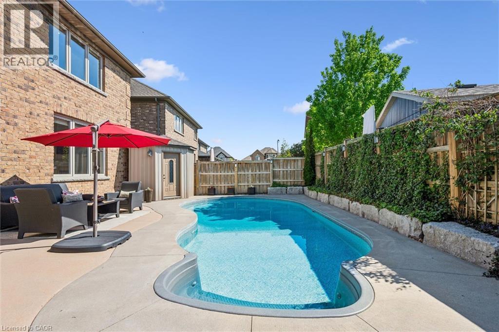 Wavy-edge inground pool with concrete surround. - 828 Copper Ridge Drive, Waterloo, ON - Outdoor With In Ground Pool