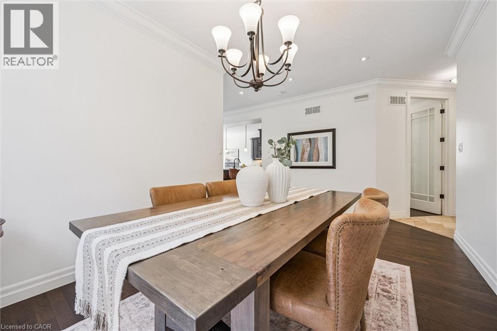 Spacious dining area featuring dark wood-finish flooring, a contemporary chandelier, crown molding. - 828 Copper Ridge Drive, Waterloo, ON - Indoor Photo Showing Dining Room