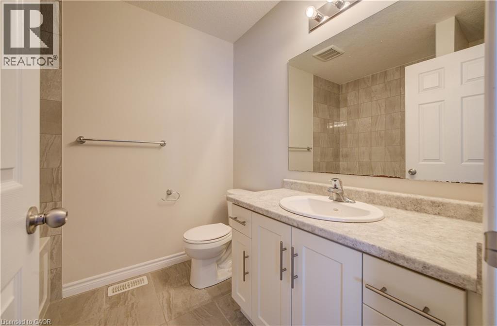 Bathroom featuring a white vanity with an integrated sink, silver-toned faucet, and a large mirror - 80 Miranda Path, Elmira, ON - Indoor Photo Showing Bathroom
