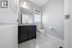 Bathroom featuring a dark wood-finish vanity with a light-colored countertop, a rectangular mirror, and a two-bulb vanity light fixture - 