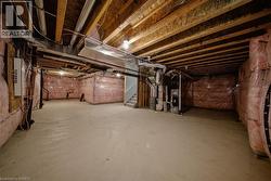 Unfinished basement offering ample space with exposed ceiling joists, concrete flooring, and wall insulation - 