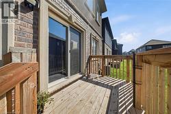 Exterior wood-plank deck with wood railings, featuring a sliding glass door entry to the interior - 