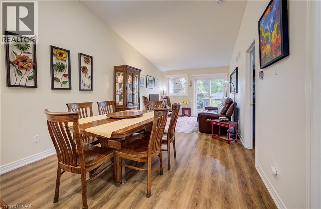 Vaulted ceiling, wood-finish flooring, sliding glass door, recessed lighting, and built-in display cabinet - 16 Steed Court, Brantford, ON