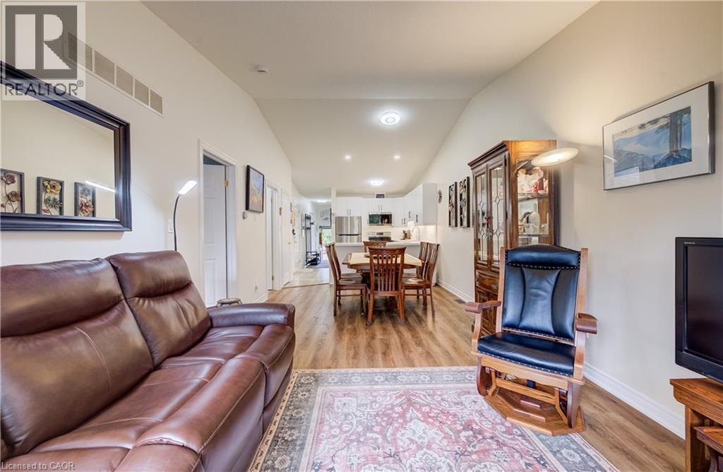 Vaulted ceiling in living area featuring wood-finish flooring - 16 Steed Court, Brantford, ON