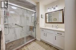 Glass-enclosed shower with a marble-effect surround and grab bars - 