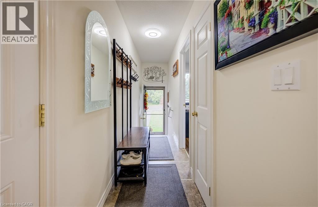 Hallway with tiled flooring, white walls, and recessed lighting - 16 Steed Court, Brantford, ON
