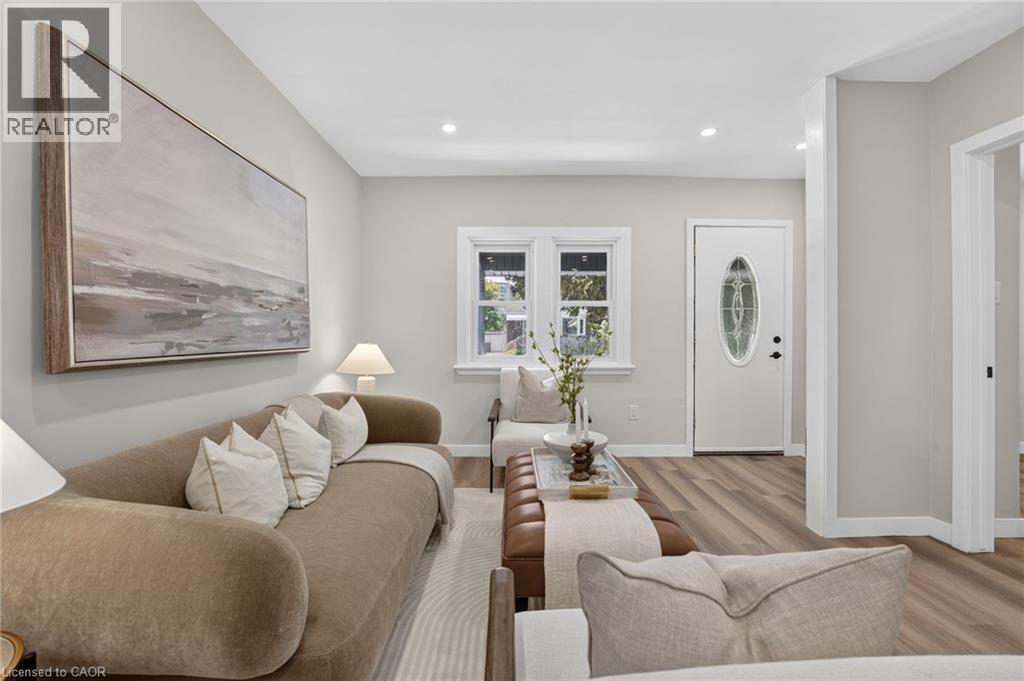 Recessed lighting, wood-finish flooring, white trim, and a white entry door with an oval glass insert - 43 E Brucedale Avenue E, Hamilton, ON
