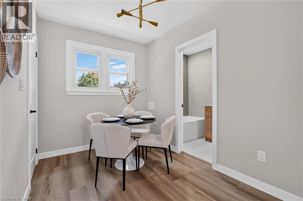 Wood-finish flooring, white trim throughout, and a modern ceiling fixture - 43 E Brucedale Avenue E, Hamilton, ON