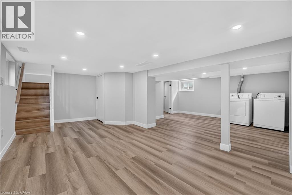 Spacious room with wood-finish flooring, recessed lighting, and a neutral color palette - 43 E Brucedale Avenue E, Hamilton, ON