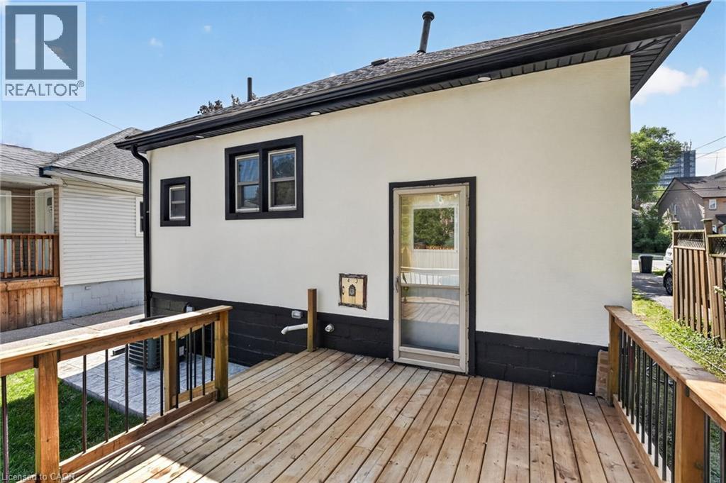 Exterior with white stucco siding, black trim, and a wood deck - 43 E Brucedale Avenue E, Hamilton, ON