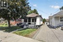 White exterior with black trim, covered front porch, concrete driveway, and detached garage - 43 Brucedale Avenue E, Hamilton, ON 