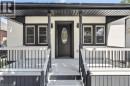 Covered front porch with black railings, decorative porch columns, and a black front door with oval-shaped glass insert - 43 Brucedale Avenue E, Hamilton, ON 