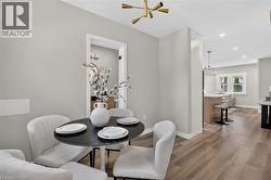 Wood-finish flooring, recessed lighting, contemporary ceiling light fixture, doorway with white trim, and a built-in kitchen island with a light-toned countertop -