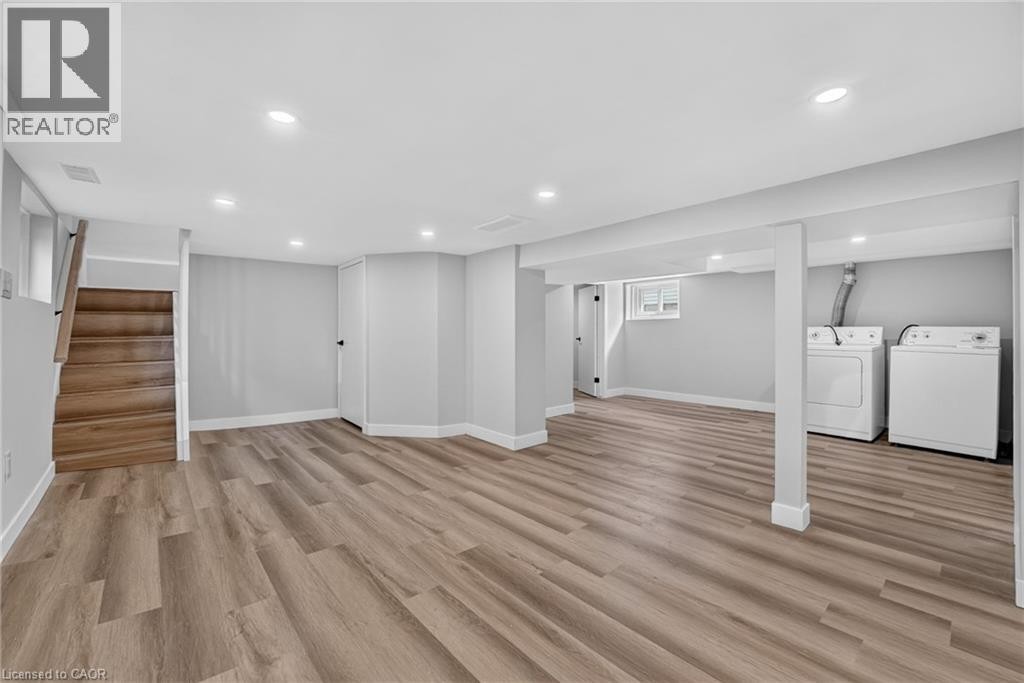 Spacious room with wood-finish flooring, recessed lighting, and a neutral color palette - 43 Brucedale Avenue E, Hamilton, ON