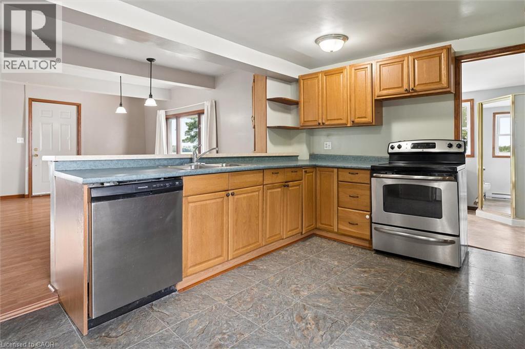 Kitchen featuring wood cabinetry, stainless steel appliances, a built-in dishwasher, and tile flooring - 5480 Line 42 Line, Mitchell, ON