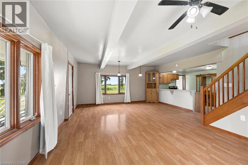 Expansive room featuring wood-finish flooring, exposed ceiling beams, and multiple windows - 5480 Line 42 Line, Mitchell, ON