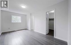 Recessed window, wood-finish flooring, overhead flush-mount lighting, and a closet with built-in shelving - 