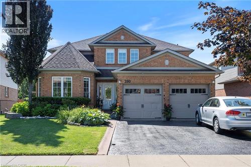 Brick exterior with multiple gables, a turret-style bay window, and a two-car garage - 260 Granite Hill Road, Cambridge, ON 
