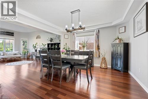 Hardwood flooring throughout, tray ceiling, recessed lighting, and a modern rectangular chandelier - 260 Granite Hill Road, Cambridge, ON 