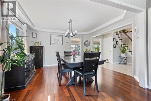 Warm wood-finish flooring with a modern chandelier - 260 Granite Hill Road, Cambridge, ON 