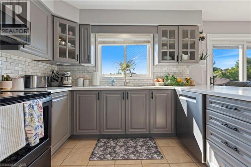 U-shaped kitchen featuring grey cabinetry, white subway tile backsplash, and light-toned countertops - 260 Granite Hill Road, Cambridge, ON 